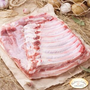 Świeży, surowy boczek wieprzowy z wyraźnymi żebrami (boczek z kością), gotowy do marynowania na BBQ.