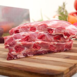 Świeże żeberka wieprzowe schabowe surowe na drewnianej desce